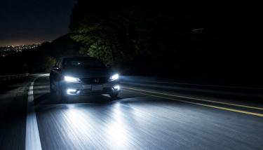 夜間の暗い道路で明るいLEDヘッドライトが前方を照らし視認性が向上している様子